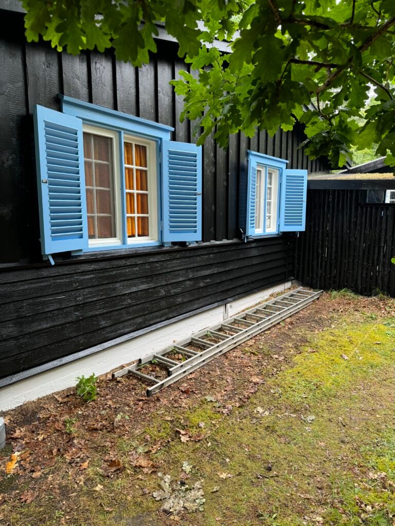Sortmalet træfacade med nymalede vinduer